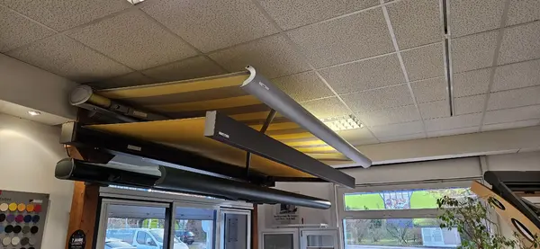Ausstellung von modernen, gelben Markisen in einem Fachgeschäft für Sonnenschutzsysteme.