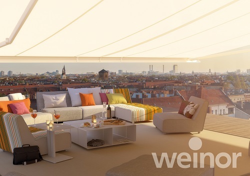 Moderne Dachterrasse mit Markise, stilvollen Lounge-Möbeln und Blick über die Stadt.